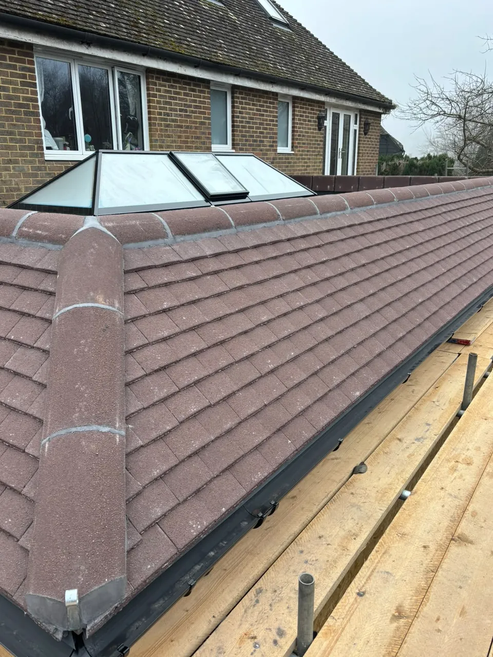 Newly tiled hip roof with rooflights, re-roof by J Wigmore Roofing near Aldershot