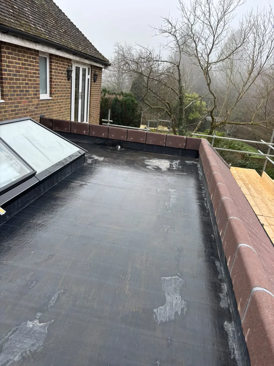 EPDM flat roof with rooflights and parapet coping from above