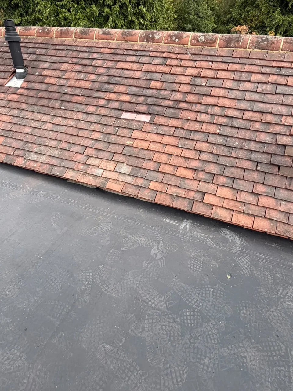 EPDM flat roof meeting a tiled roof edge