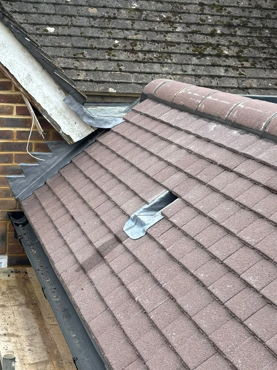 Roof junction leadwork being renewed with tiles lifted