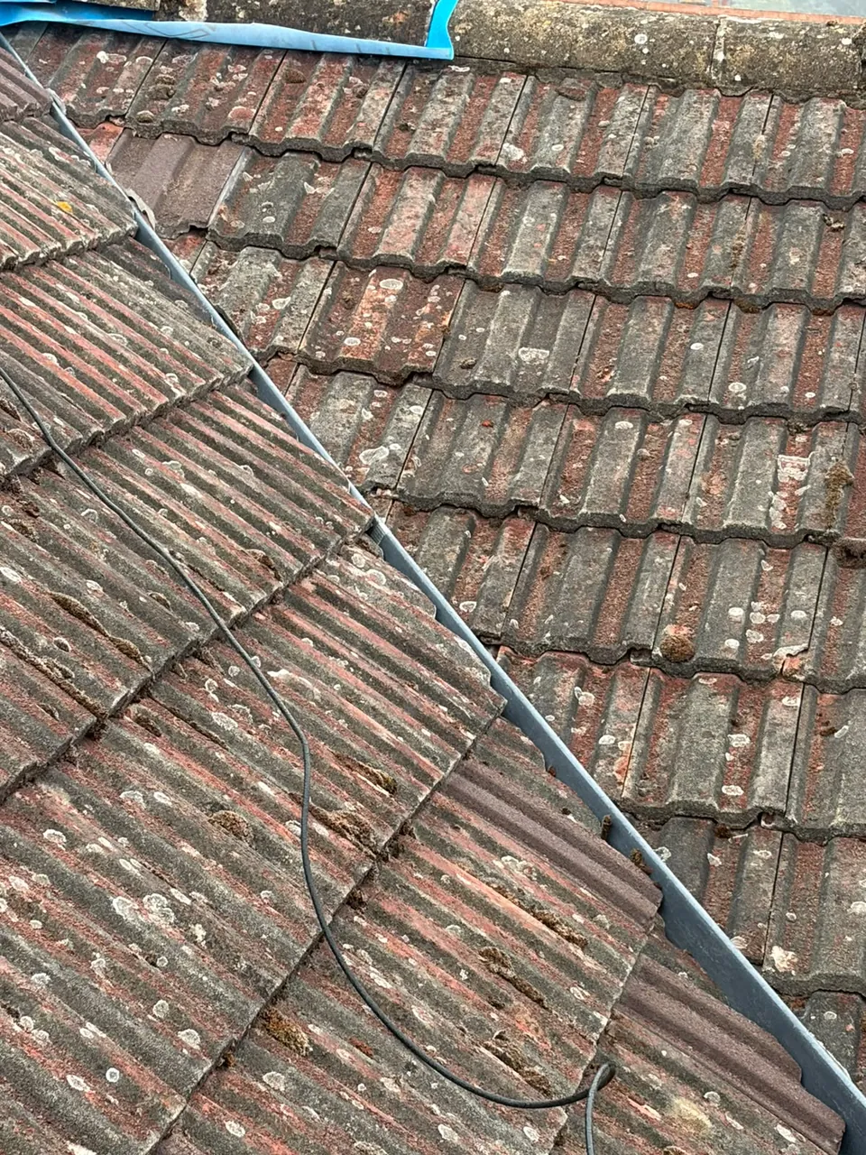 Worn tiled roof valley before repair