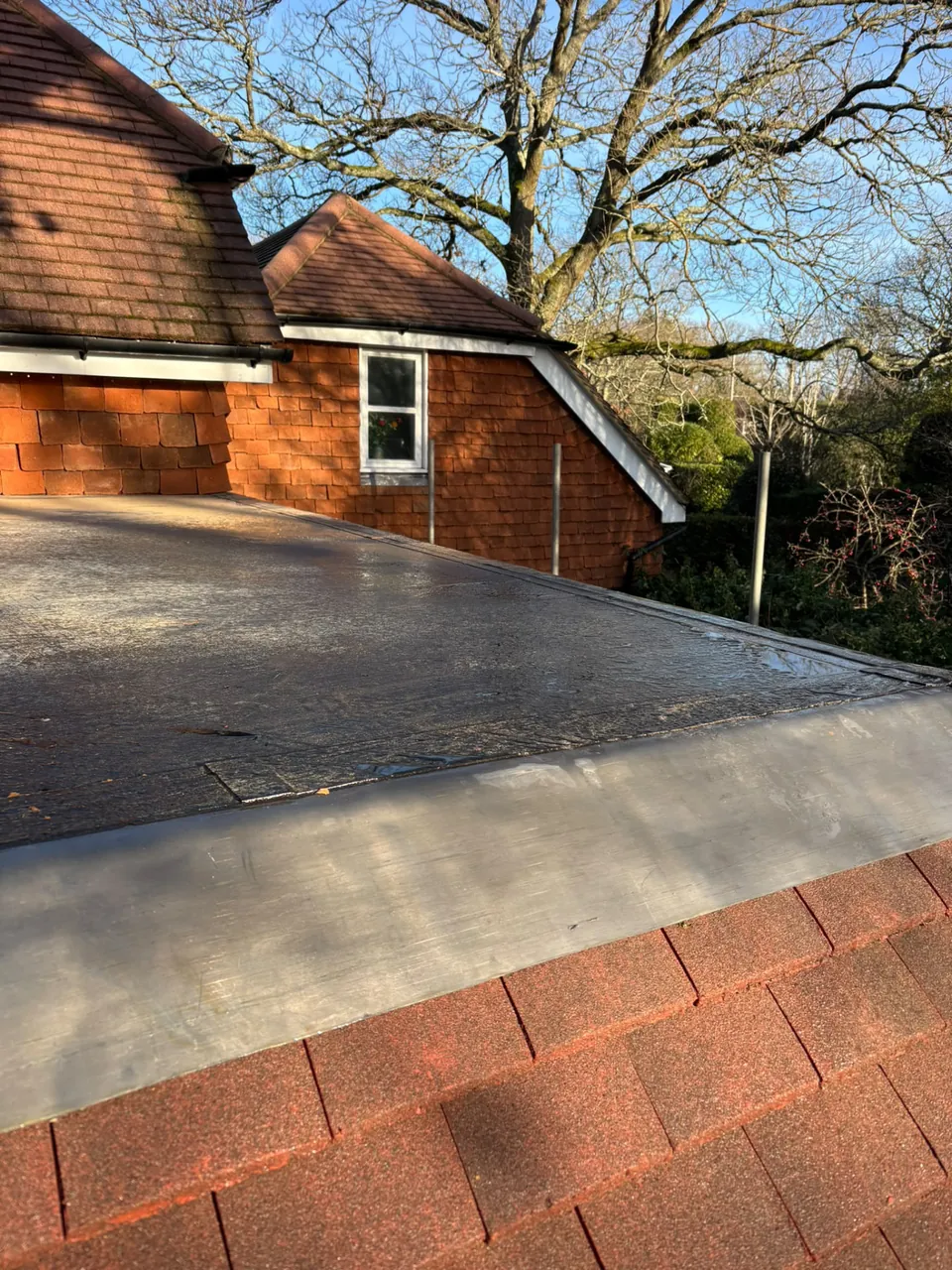 Lead apron at the junction of a flat roof and tiled roof