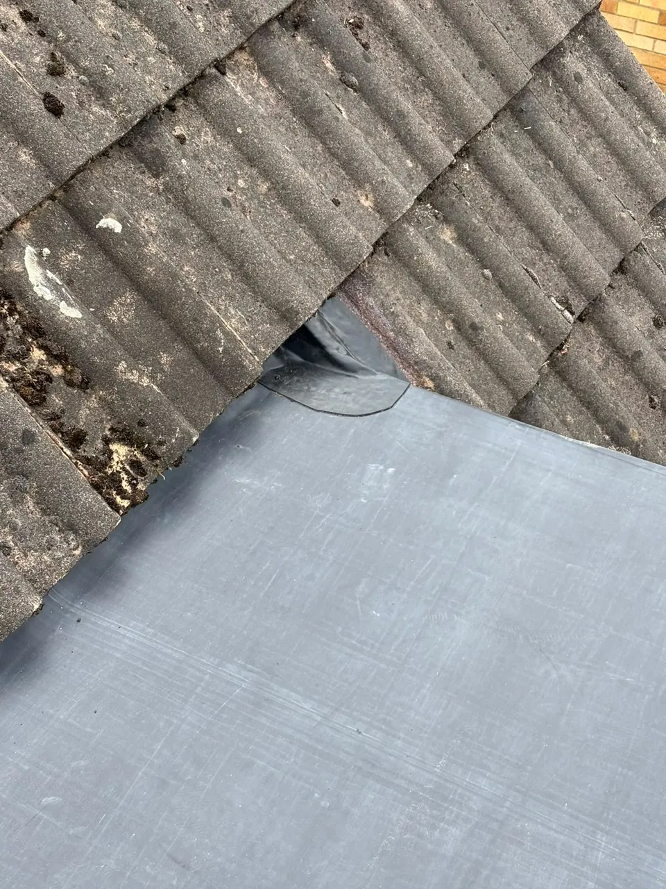 EPDM flat roof junction detail against pitched roof tiles