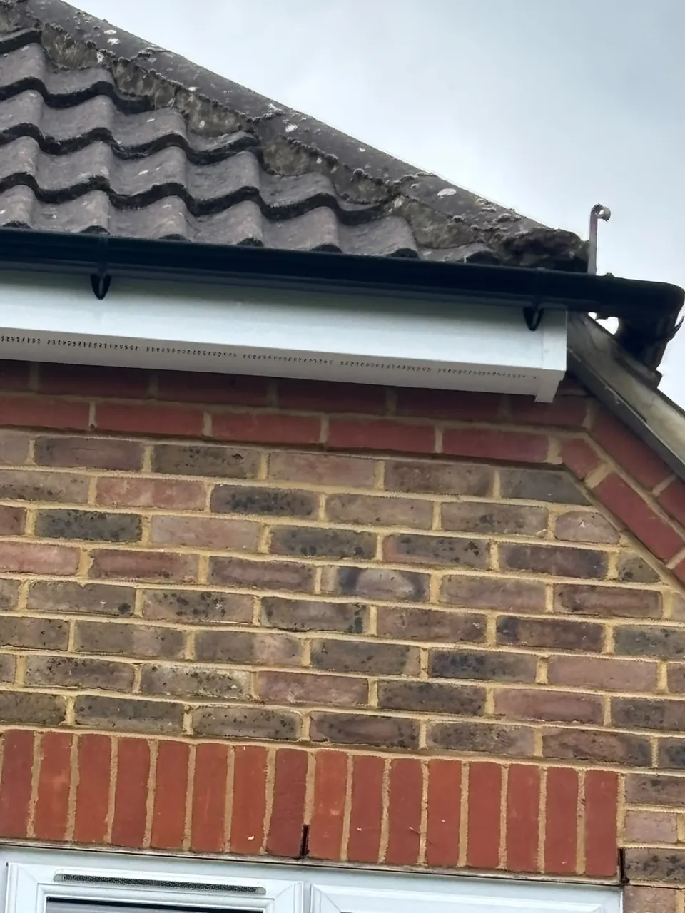 New white uPVC fascia above brickwork and window