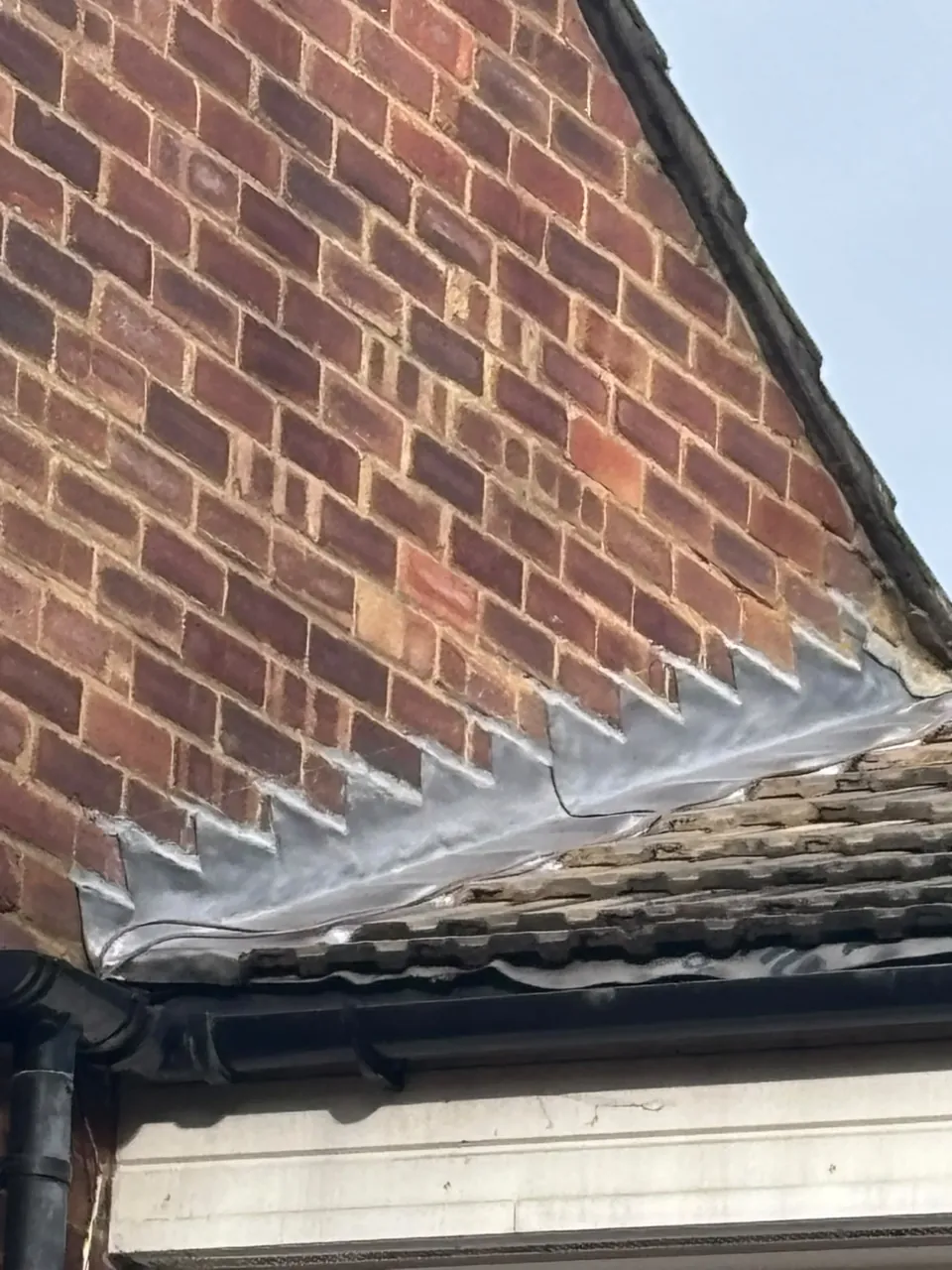Lead stepped flashing at a brick wall and roof junction