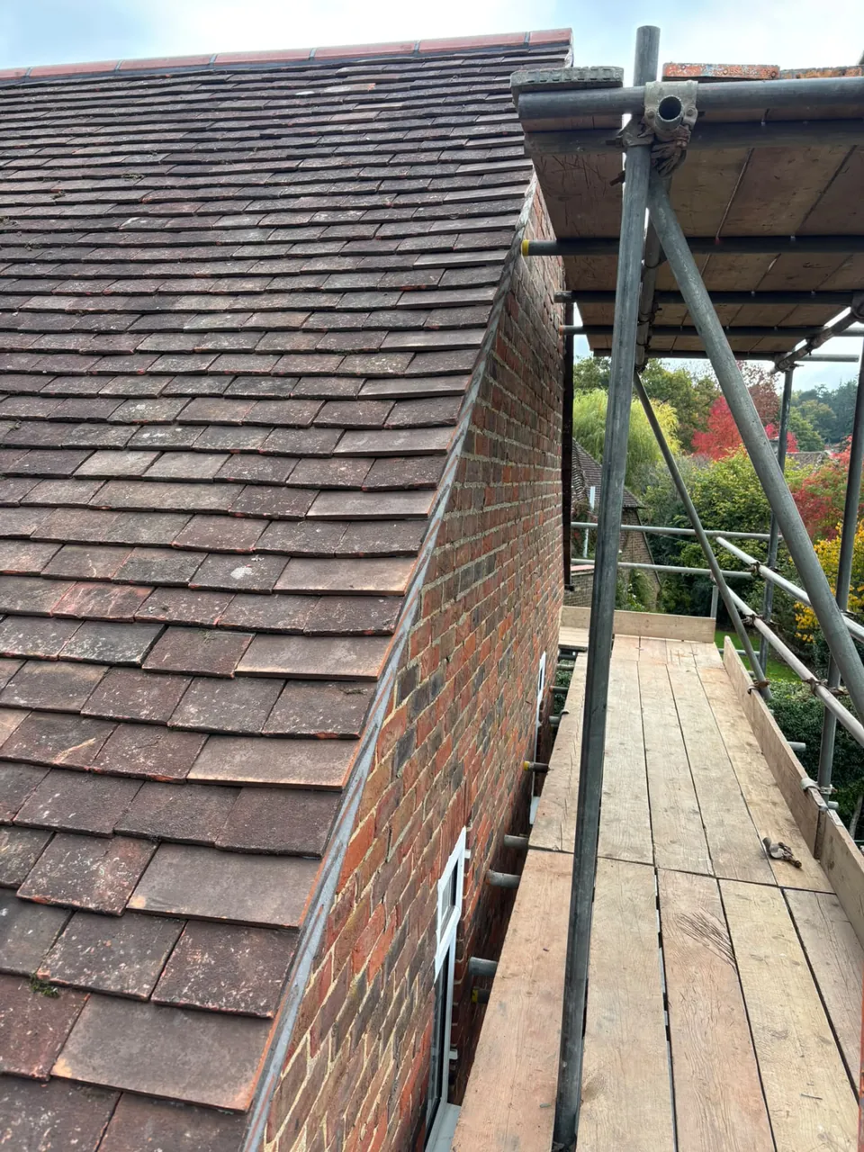 Plain tile roof verge finished beside brick gable on a re-roof