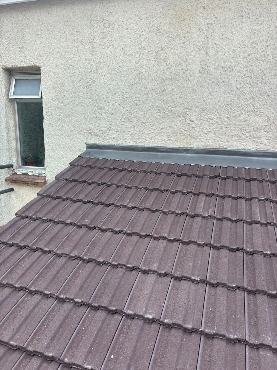 Lead flashing where a lean-to roof meets a rendered wall