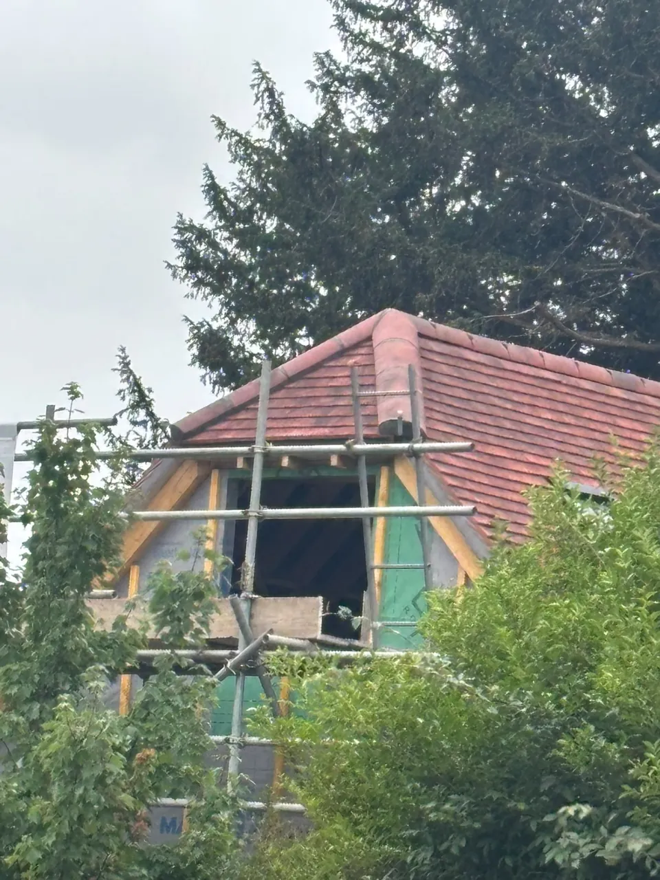 Dormer roof under construction with scaffolding and timber framing